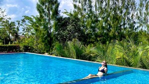 A clear blue swimming pool with a person relaxing in the water. - Lodge Moni Essara Kompot (Kampot)