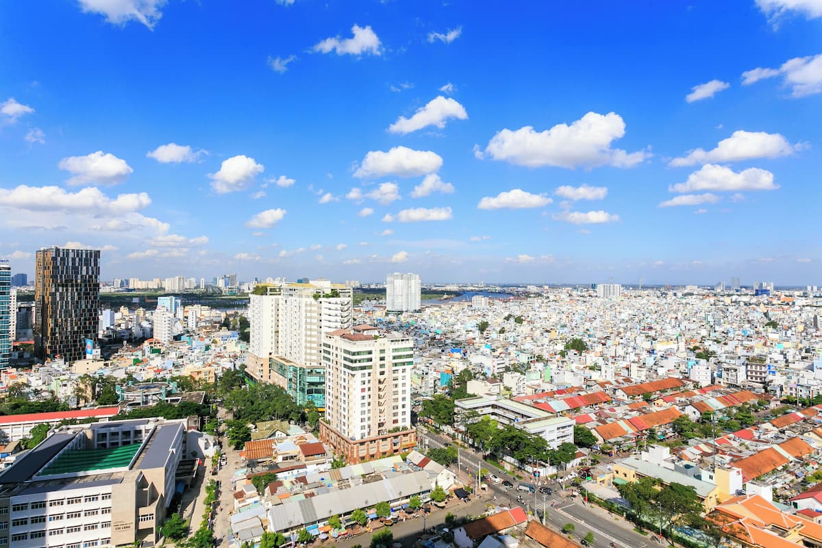 A cityscape with high-rise buildings, a dense urban area, and a clear blue sky.