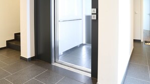 A modern hallway with a black-framed door leading to a bright room. - Apartment "London" 63m² |Cologne|Messe|Phantasialand|Bonn (Erftstadt)