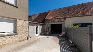 A residential property with a stone facade, a tiled roof, and a covered patio area. - La Maison de Fabrice (Vauchamps)