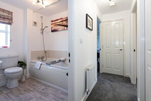 A bathroom with a bathtub, toilet, and shower. - Manchester - House - (Manchester)