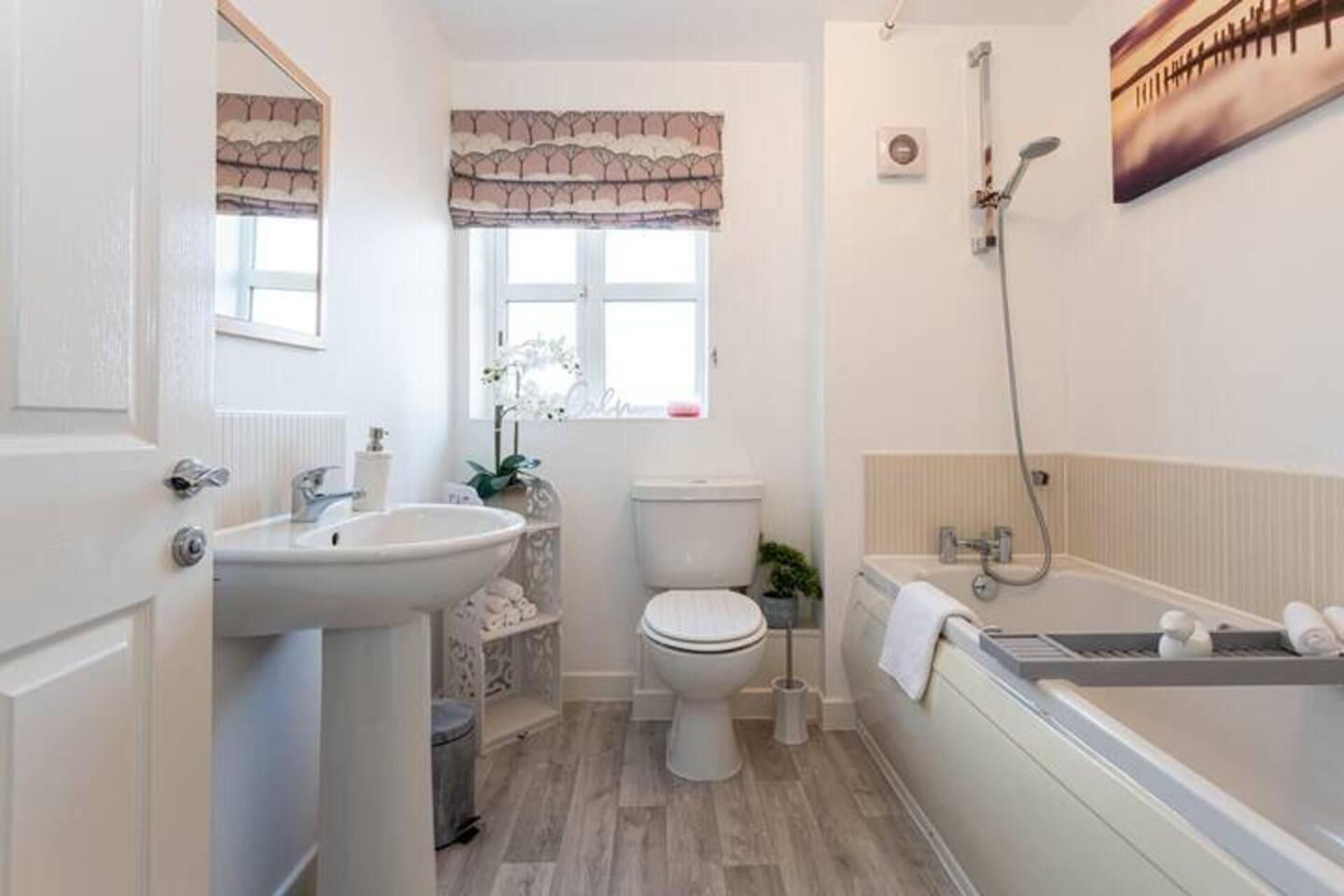 Et badeværelse med vask, toilet og badekar.