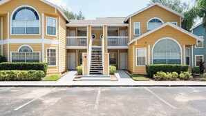 A two-story building with a central staircase, balconies, and a gated entrance. - Disney, Pool, Hot Tub, Gym! (Kissimmee)