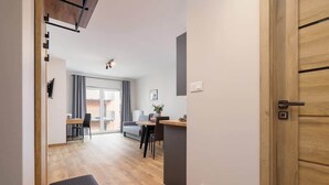 Un intérieur moderne avec un plancher en bois, un coin repas comprenant une table et des chaises, et un canapé.