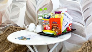 A table with a menu, a bottle of Dasani water, a pack of Mashi snacks, and a carton of milk. - Ben's House 3 (Da Nang)