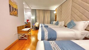 A hotel room with two beds, a desk, and a chair. - ALRITZ ALMADINAH HOTEL - فندق الريتز المدينة (Madinah)