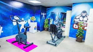 A gym with exercise equipment, a brick wall mural, and lockers. - ALRITZ ALMADINAH HOTEL - فندق الريتز المدينة (Madinah)