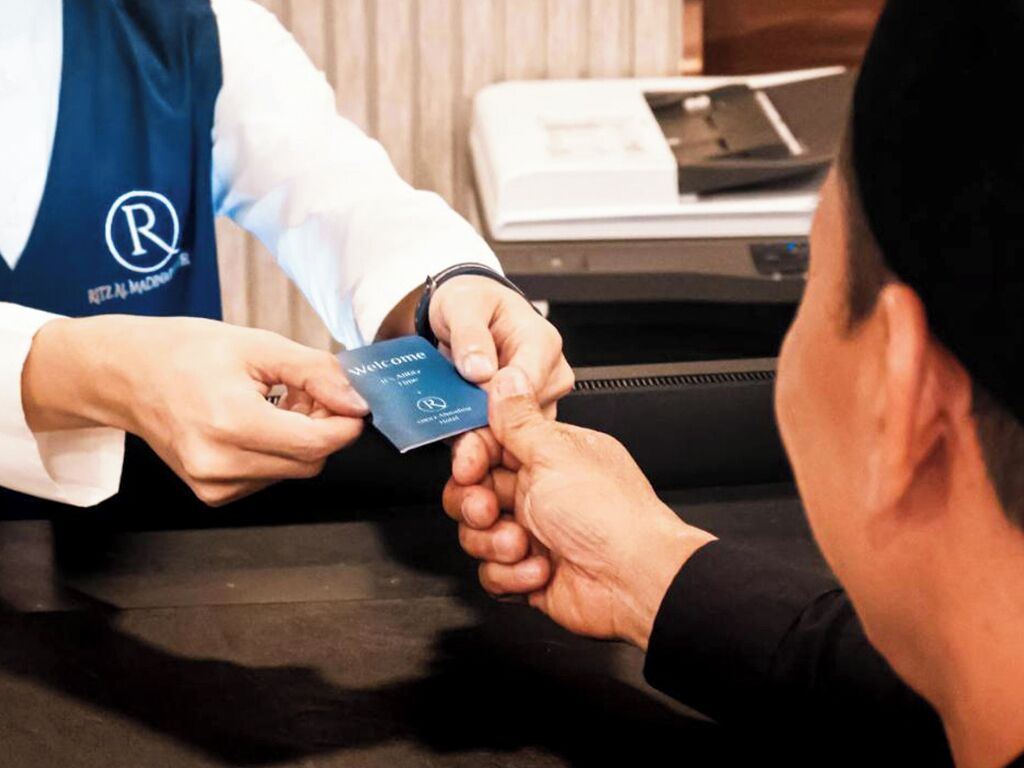 Une personne reçoit une carte d'un membre du personnel de l'hôtel.