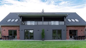 A modern two-story building with a flat roof, large windows, and a satellite dish. - Ferienwohnung Zur Örtze (Faßberg)