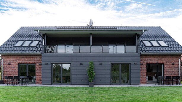 A modern two-story building with a flat roof, large windows, and a satellite dish. - Ferienwohnung Heideloft (Faßberg)