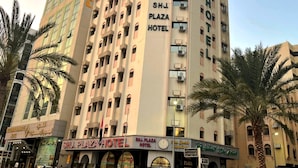 Un hôtel à plusieurs étages, doté de balcons et de climatiseurs.