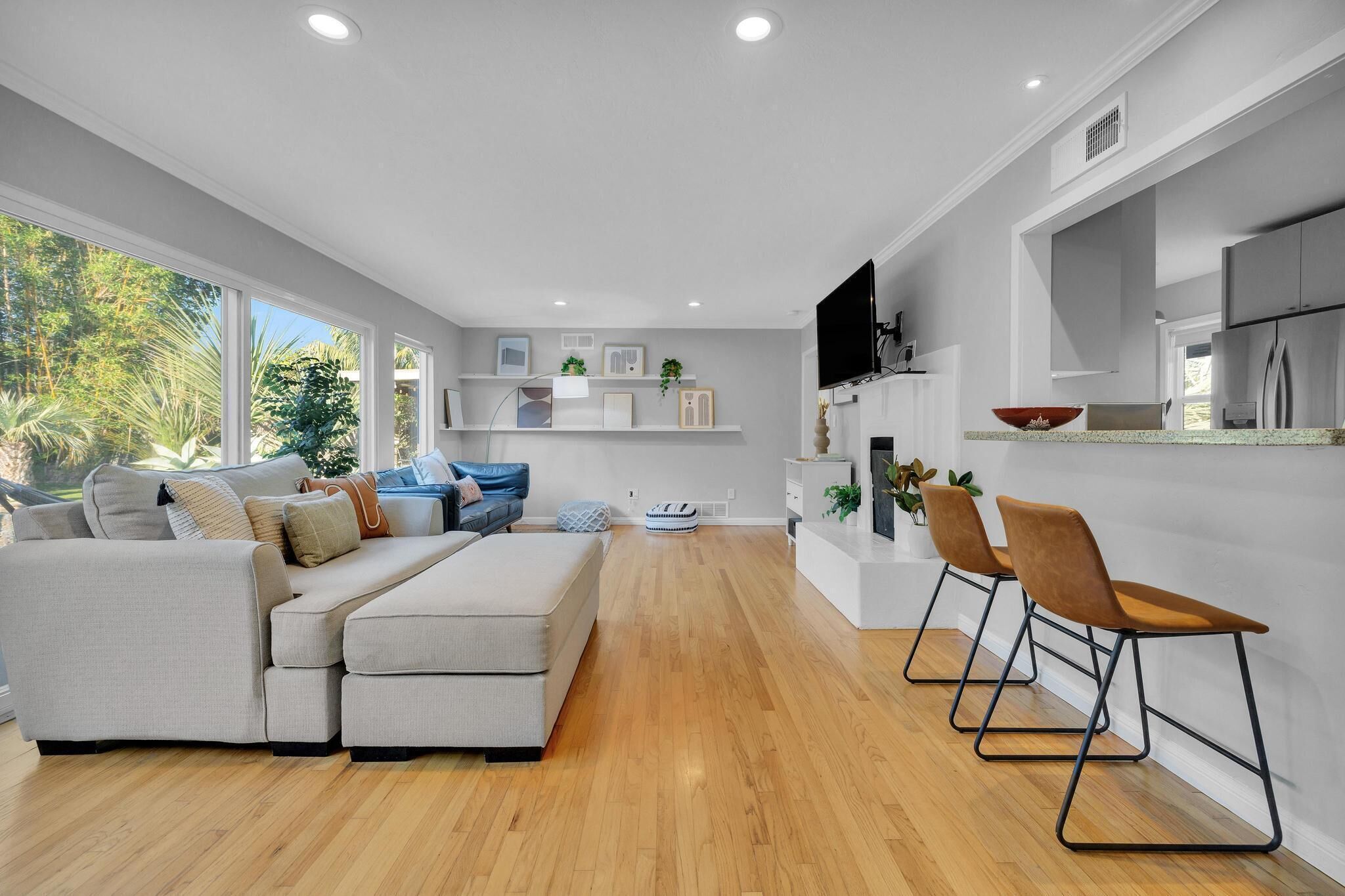 A modern living room with a sofa, chairs, and a TV.