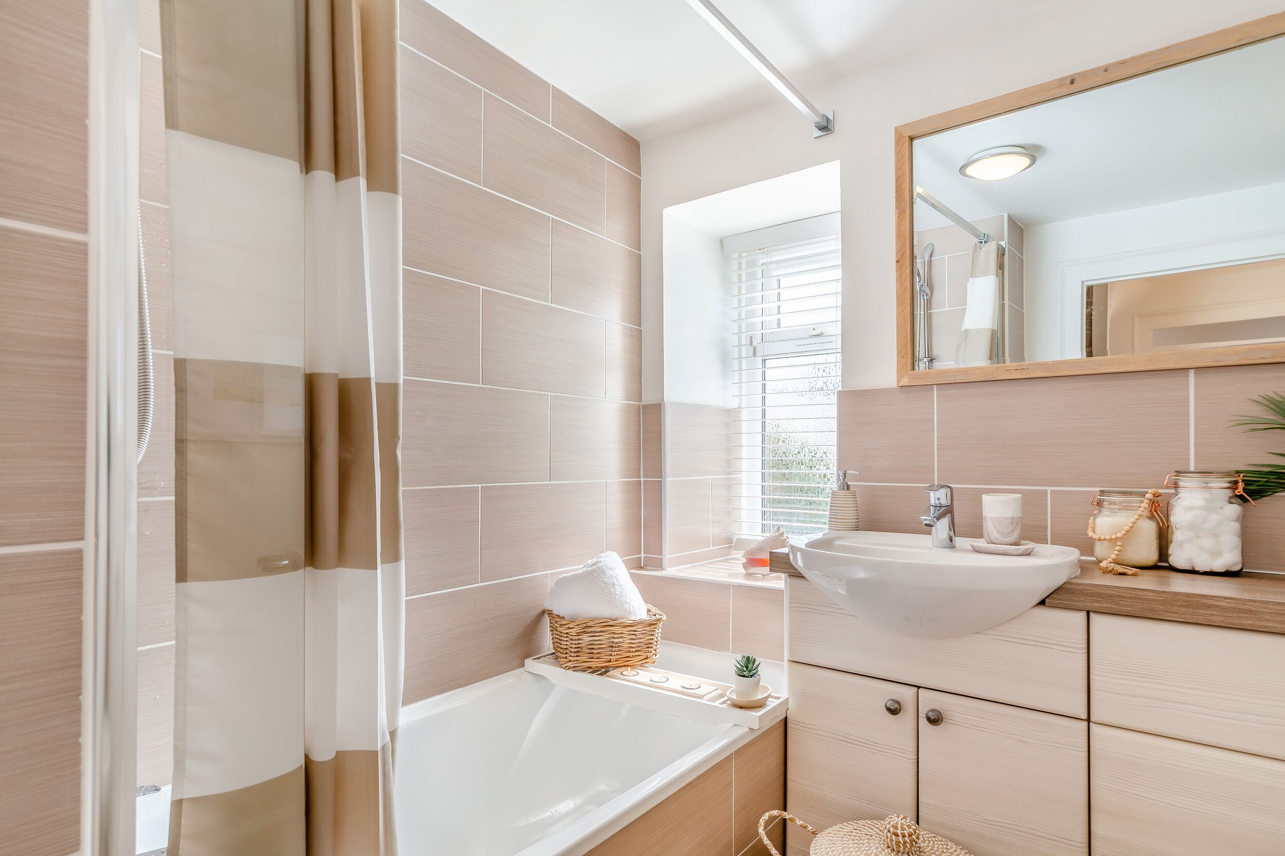A modern bathroom with a bathtub, a sink, and a mirror.