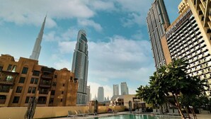 Un espace piscine offrant une vue sur de grands immeubles, dont une tour particulièrement imposante.