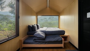 A compact bedroom with a bed, a window, and a door.