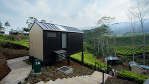 A cabin with a sloped roof, a small porch, and a sign indicating it is cabin number 26.
