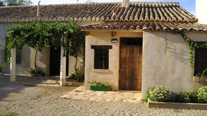 Un petit bâtiment avec un toit en tuiles, une porte en bois et une fenêtre.