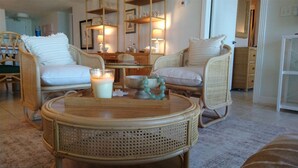 A cozy room with wicker furniture, a round table, and a candle.