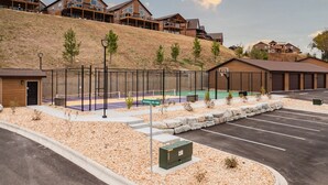 Una zona residencial con casas modernas, una cancha de baloncesto y un estacionamiento.