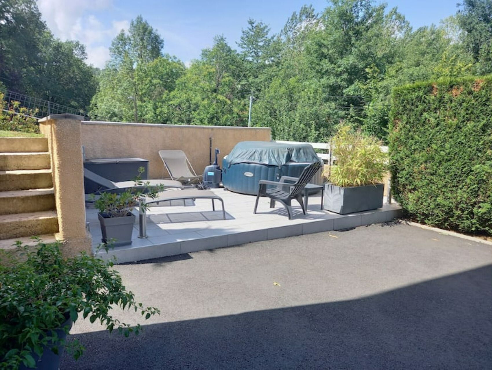 Une terrasse avec mobilier d’extérieur, un barbecue et un espace salon abrité.
