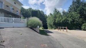 A gated driveway leading to a building with a balcony. - Appartement en Aveyron (Aubin)