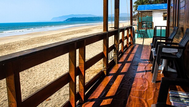 A wooden deck with a view of the beach and ocean. - Dersy Beach Resort (Canacona)