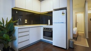 A modern kitchen with white cabinetry, a stainless steel oven, and a Samsung refrigerator. - Lovely Studio Close to the Wharf (Auckland)