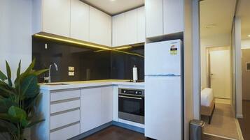A modern kitchen with white cabinetry, a stainless steel oven, and a Samsung refrigerator.
