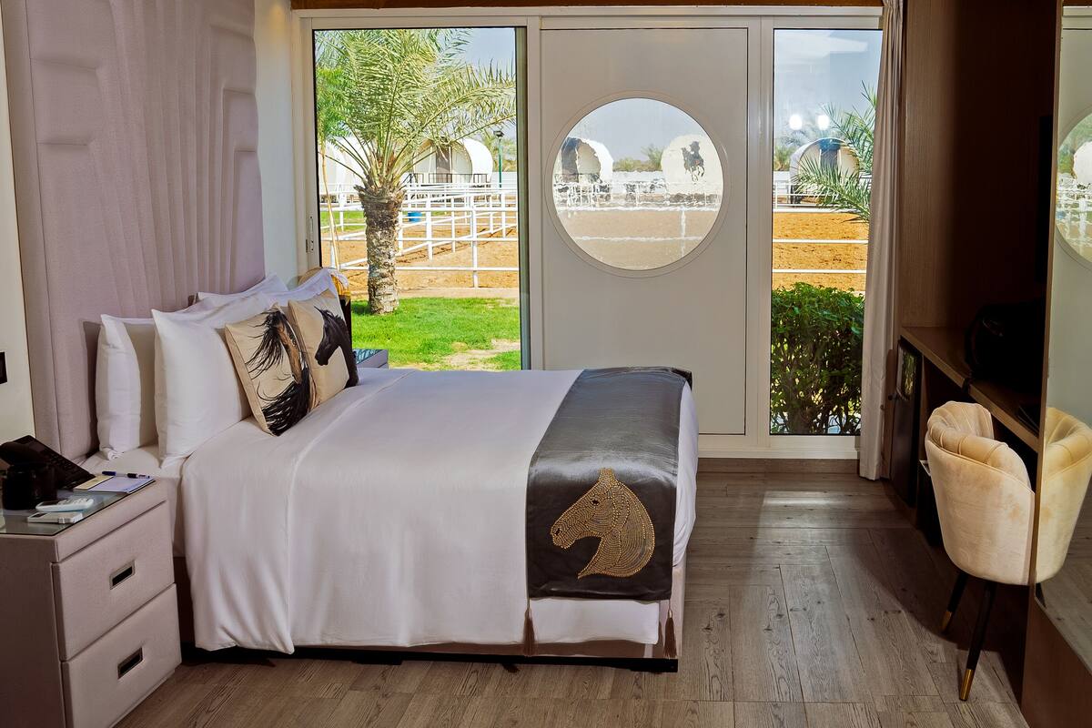 A bedroom with a bed, bedside table, and a chair.