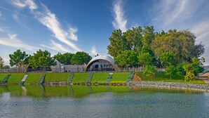A modern building with a dome structure, surrounded by a landscaped garden and a body of water. - NIRVANA RETREAT (Ras Al Khaimah)