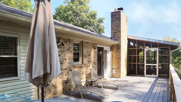 A patio with outdoor furniture, a brick house, and a glass door leading to a covered area. - Cozy Country Cottage (Culleoka)