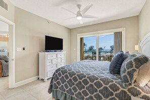 A bedroom with a bed, a dresser, a ceiling fan, and a large window with a view. - Top Floor Oceanfront 3 Bedroom villa with panoramic views and community pool (Hilton Head Island)