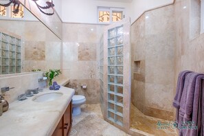 A bathroom with a bathtub, a toilet, and a sink. There is a shower with a glass door.