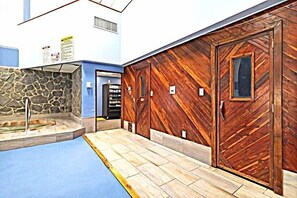 A pool area with stone walls and wooden doors.