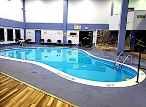 An indoor swimming pool with a blue interior, surrounded by a wooden deck and a blue and white wall. - 4314 Mountain View Suite w/Pool, hot tub & more (Beech Mountain)
