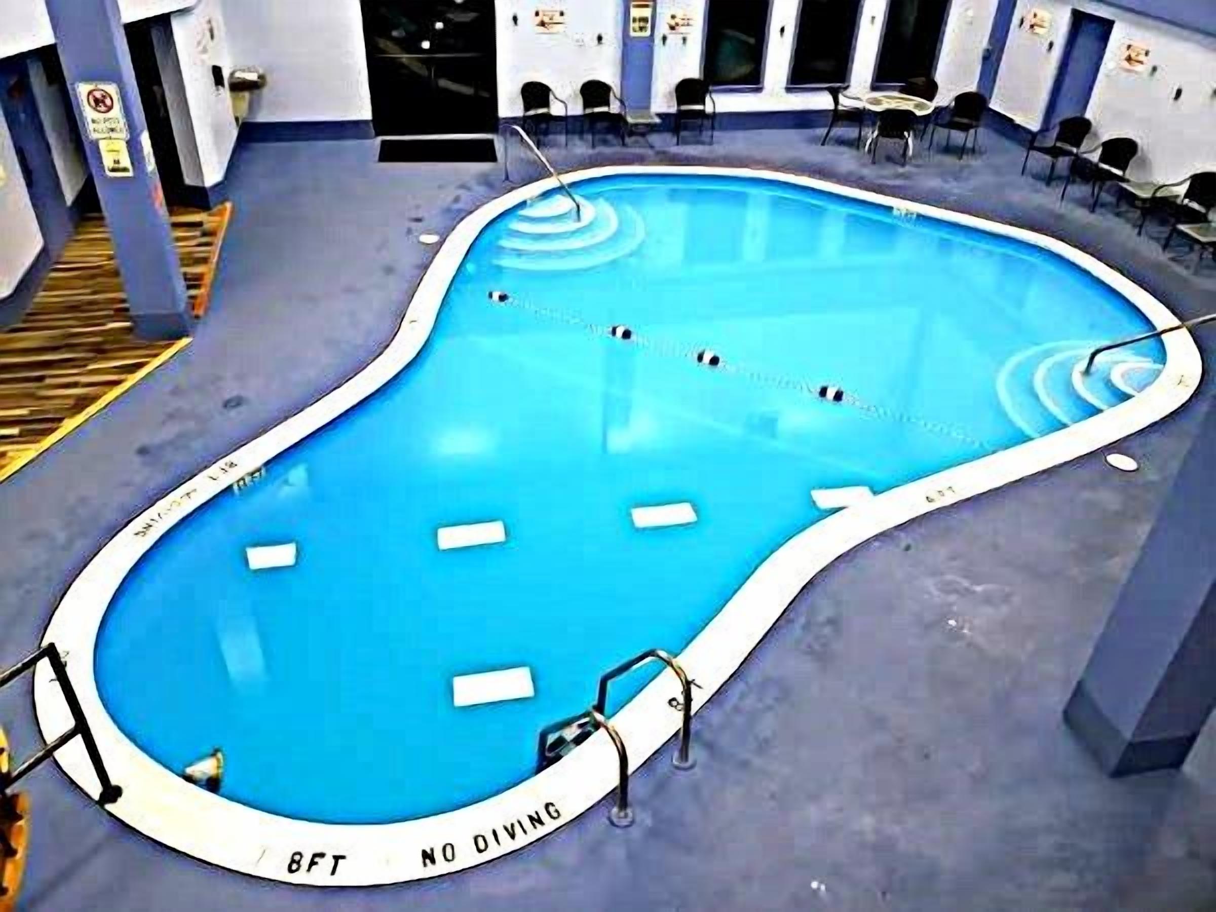 A swimming pool with a 'No Diving' sign and a 'No Diving' label on the edge.