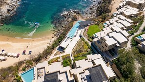 An aerial view of a coastal hotel with a swimming pool, beach, and rocky shoreline. - Endless Ocean Views and Direct Beach Access (Huatulco)
