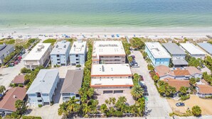 Ein Luftbild eines Küstenhotels mit mehreren Gebäuden, Parkplätzen und einem Strand im Hintergrund.
