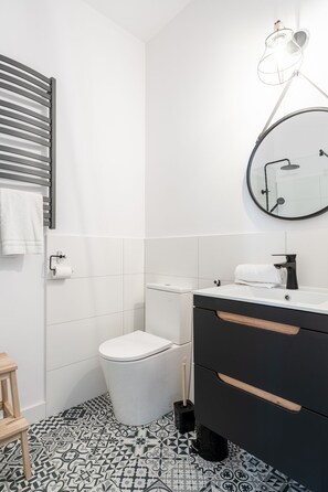 Une salle de bain moderne avec des toilettes, un lavabo et un miroir.
