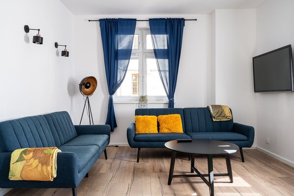 Un salon moderne avec deux canapés, une table basse et un lampadaire.