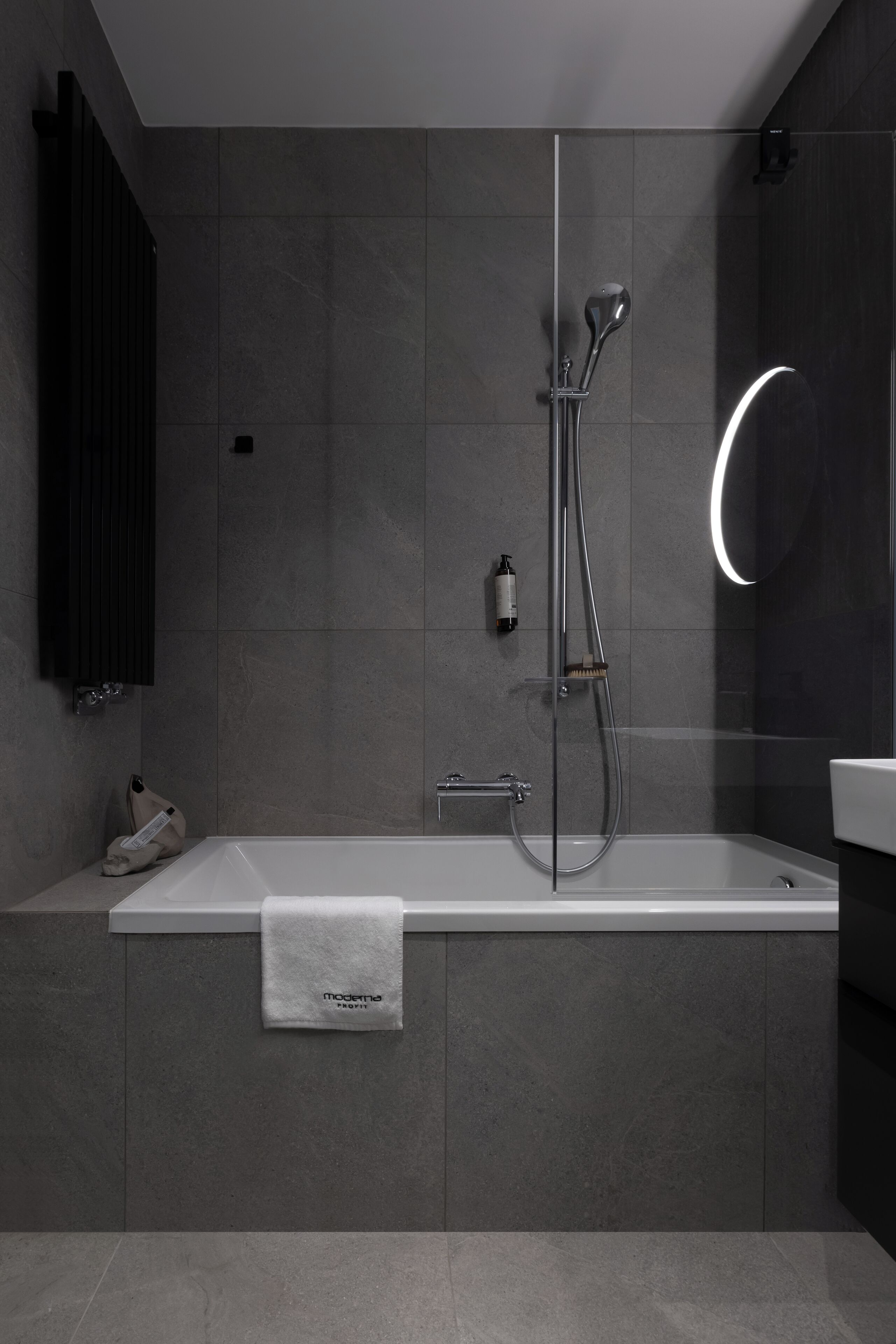 Een moderne badkamer met een badkuip, douche en een douchecabine met glazen wanden.