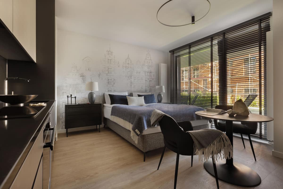 A modern bedroom with a bed, bedside tables, a desk, and a chair.
