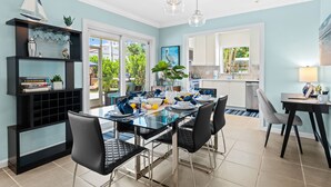 A modern kitchen with a glass dining table, black chairs, and a black bookshelf. - Peaceful Tropical Escape with Heated Pool Near Fort Lauderdale Beach! (Fort Lauderdale)