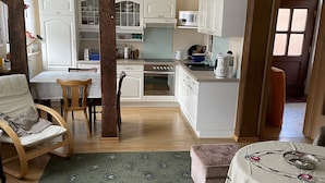 Un amplio espacio de estar con una mesa de comedor, un sofá y una cocina al fondo.