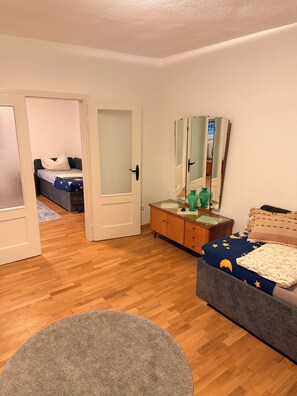 Una habitación con cama, cómoda, espejo y un tapete redondo.