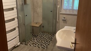 Un baño con ducha, bañera y ventana.