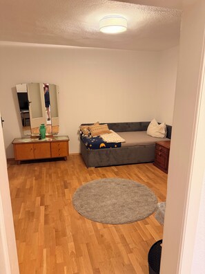 Una habitación con una cama, un tocador, un espejo y un tapete redondo.