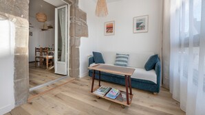 Un soggiorno accogliente con un tavolino in legno, un divano blu e un'area pranzo con sedie e tavolo.