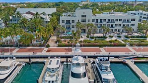 A marina with several yachts docked, a bridge, and a modern building with balconies. - **MODERN MAJESTY @ THE ANNEX** Condo & Pool + Last Key White Glove Service... (Key West)