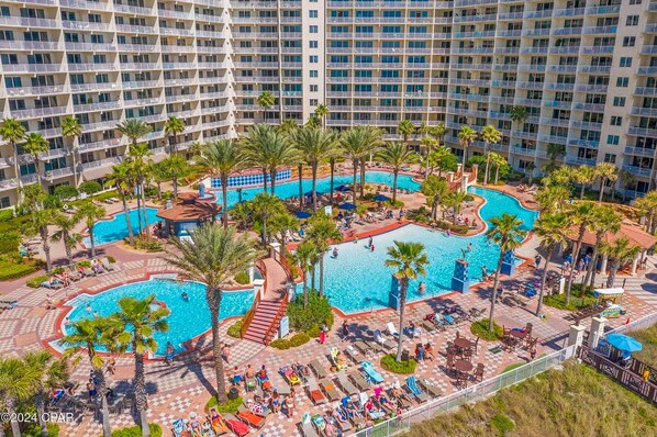 Relax by the pool surrounded by palm trees and enjoy lounge chairs, sunbeds, and a children's play area.